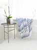 An extra large, blue and white striped Turkish bath towel hanging over a bathtub.