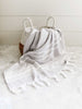 A gray and white striped Turkish towel decoratively hanging over a basket.