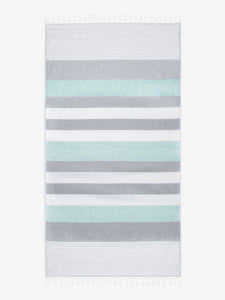 An oversized, teal and gray striped Turkish cotton towel with white fringe laid out. 