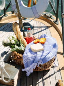 Luxury blue and white striped turkish towel used for a picnic on a sailboat.