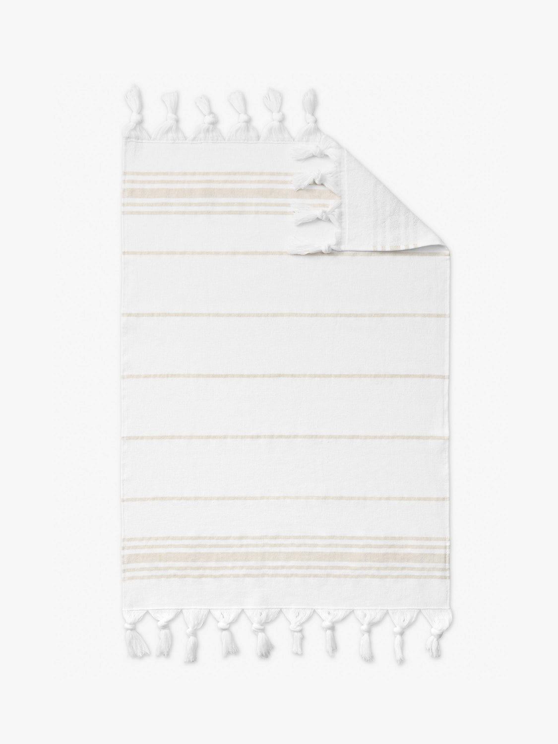 A tan and white luxury Turkish hand towel laid out.
