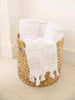 Three tan and white Turkish towels rolled up decoratively in a basket.