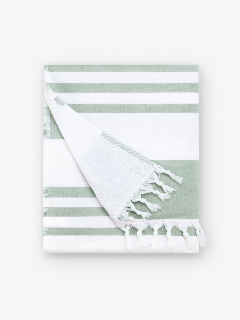 A folded sage and white striped Turkish hand towel with white fringe.
